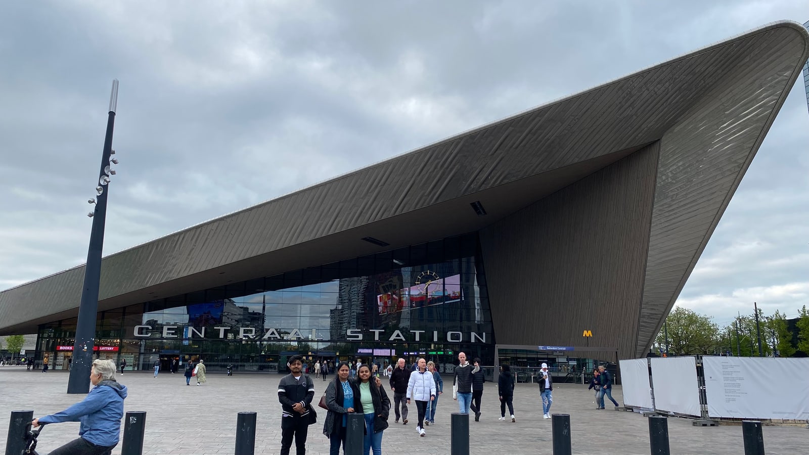 Amogh with his family on the Stationsplein in front of Rotterdam Centraal, the great pointed steel roof and the 