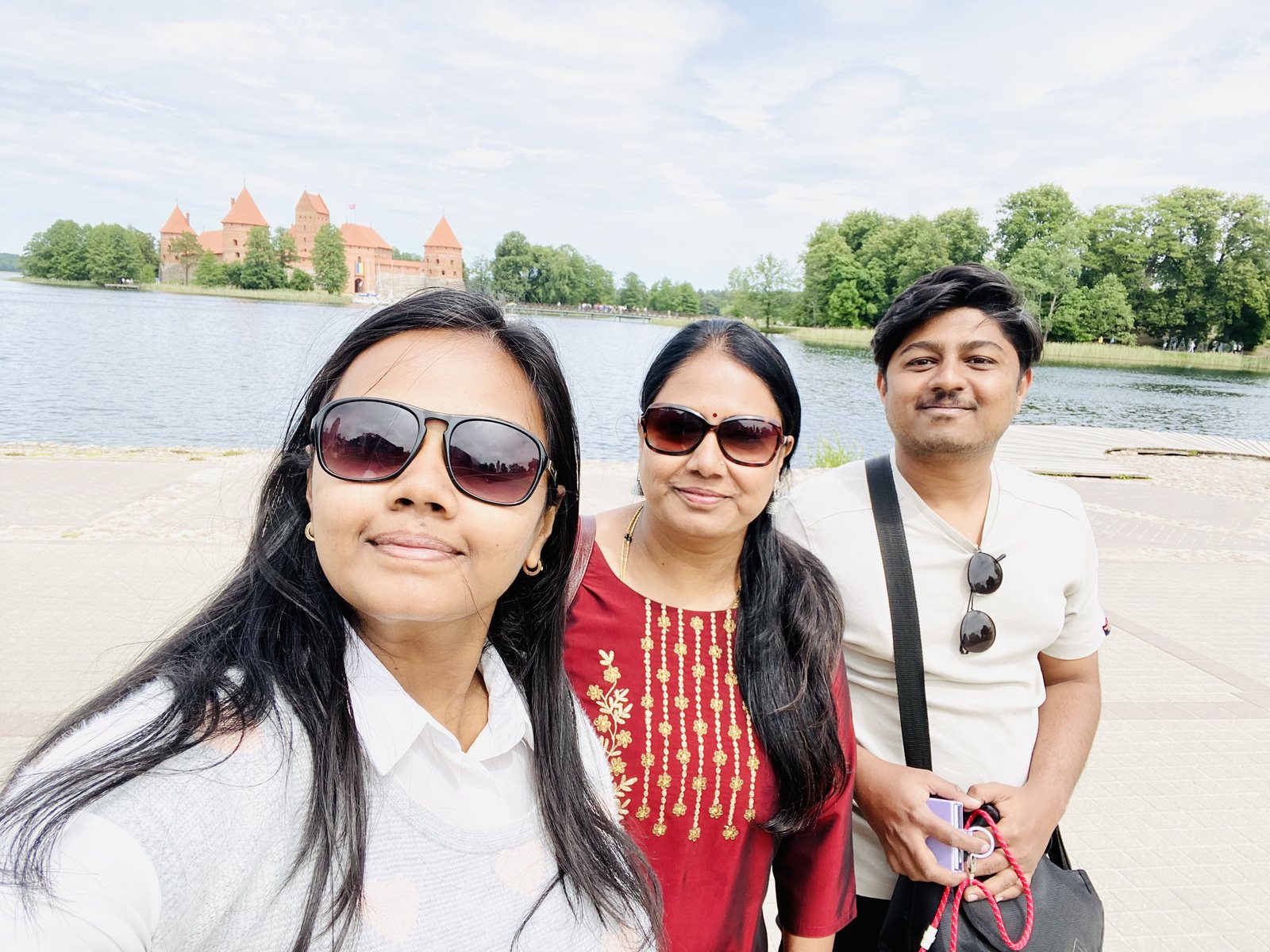 Amogh with his family on the shore of Lake Galvė, the towers of Trakai Island Castle rising across the water behind them