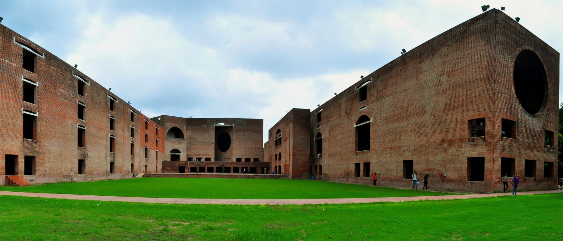 Indian Institute of Management campus / dorms — Brick arches framing shaded corridors.
