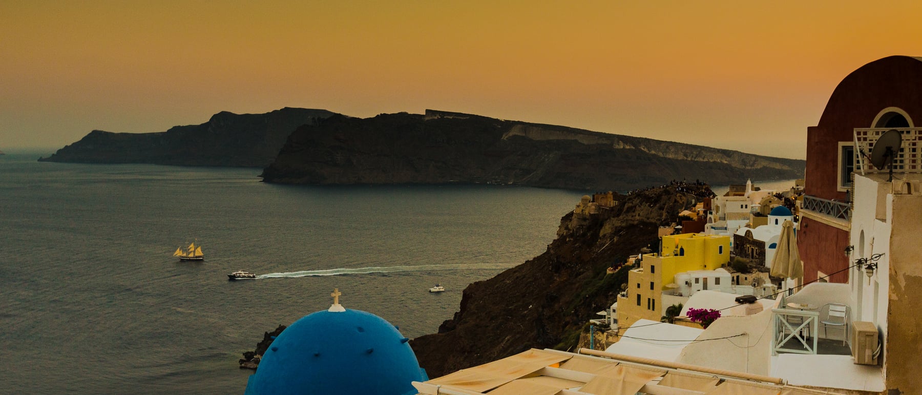Santorini cave dwellings — Whitewashed vaulted homes cut into volcanic rock.