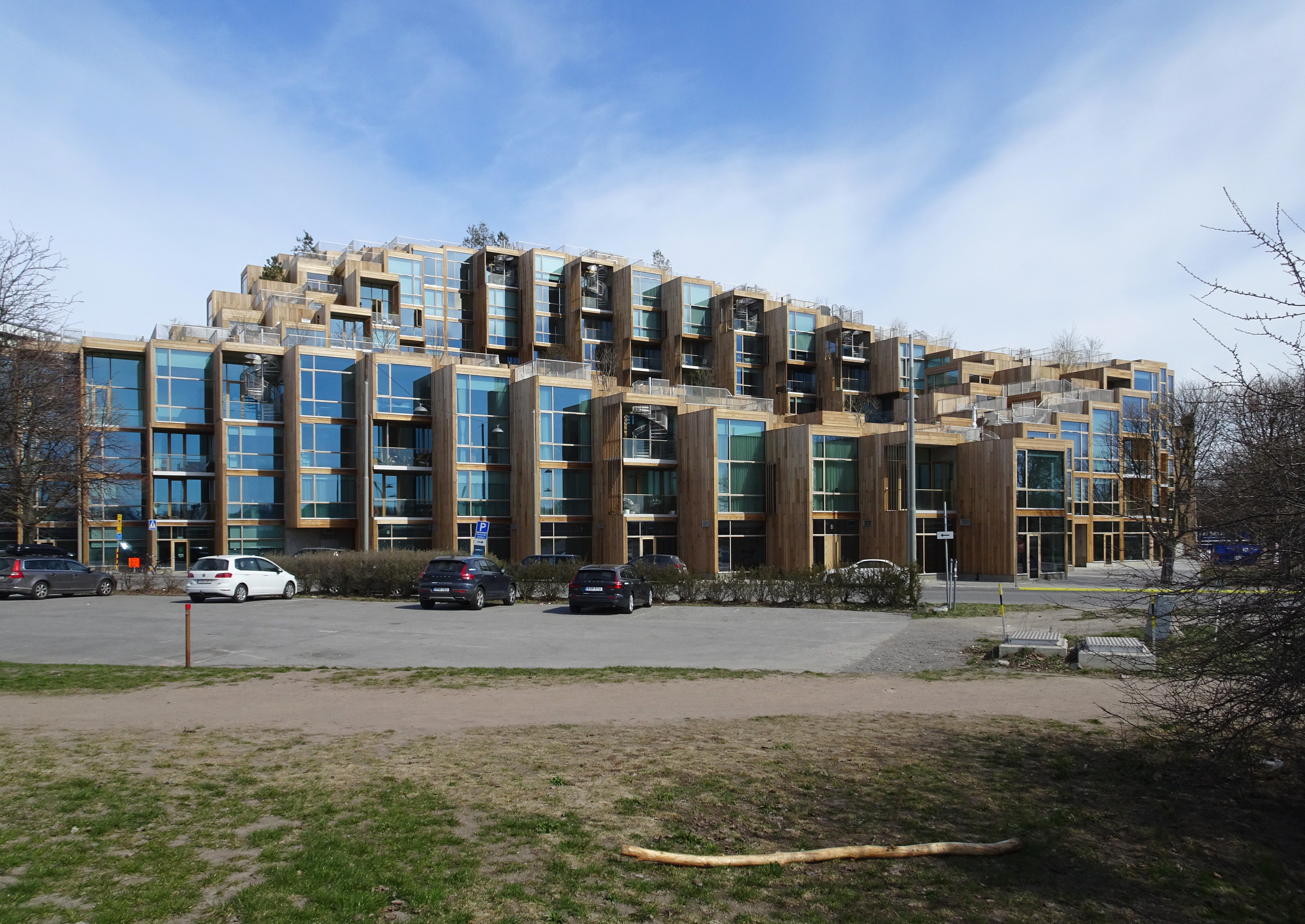 Exterior daytime view of the completed 79 & Park building on the edge of Gärdet, showing the stepped cedar-clad massing.