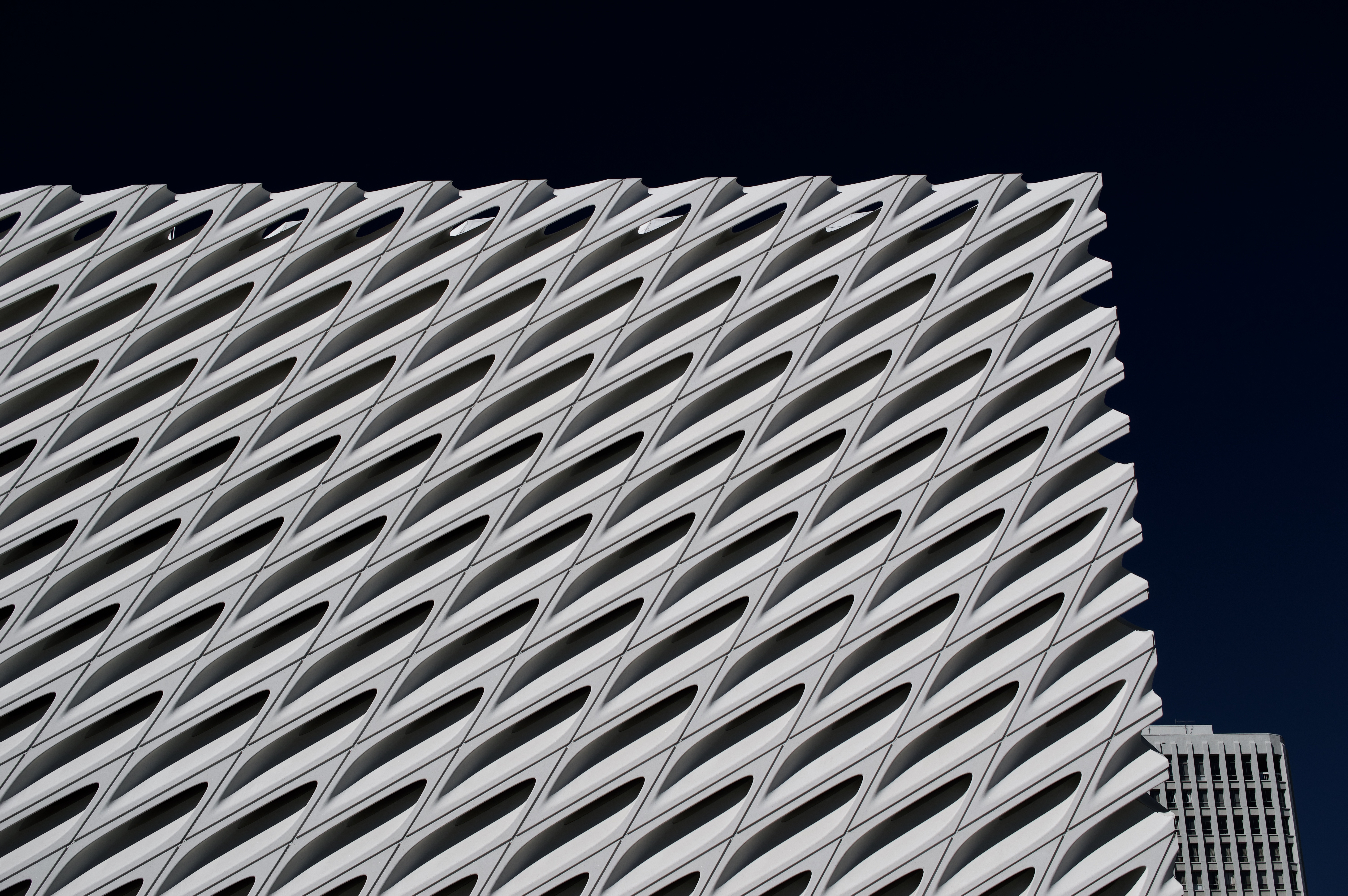 Street-level view of The Broad's porous white veil facade in downtown Los Angeles.