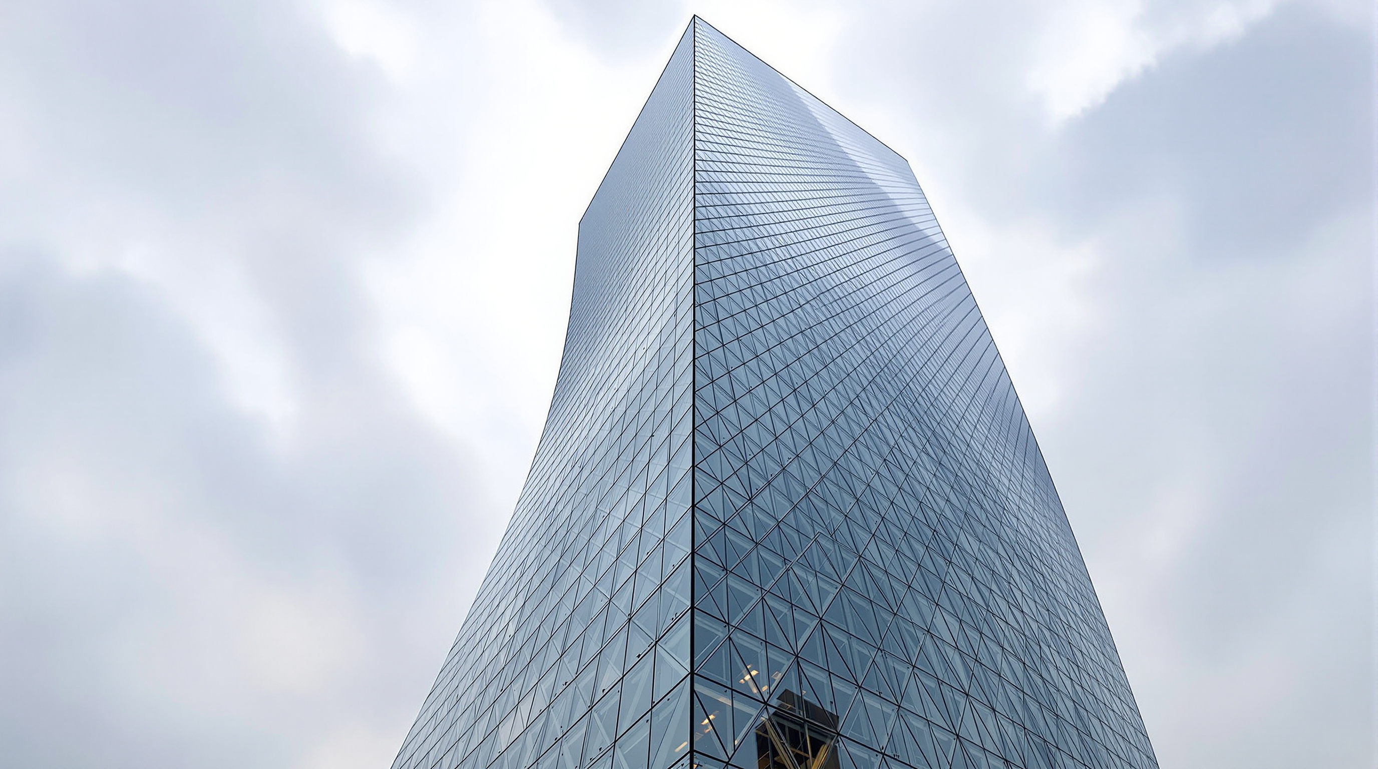 Looking straight up the corner of the CCTV Headquarters, the glass curtain wall gridded by its irregular diagonal steel bracing, the mesh visibly tightening toward the leaning corner where the structural forces concentrate