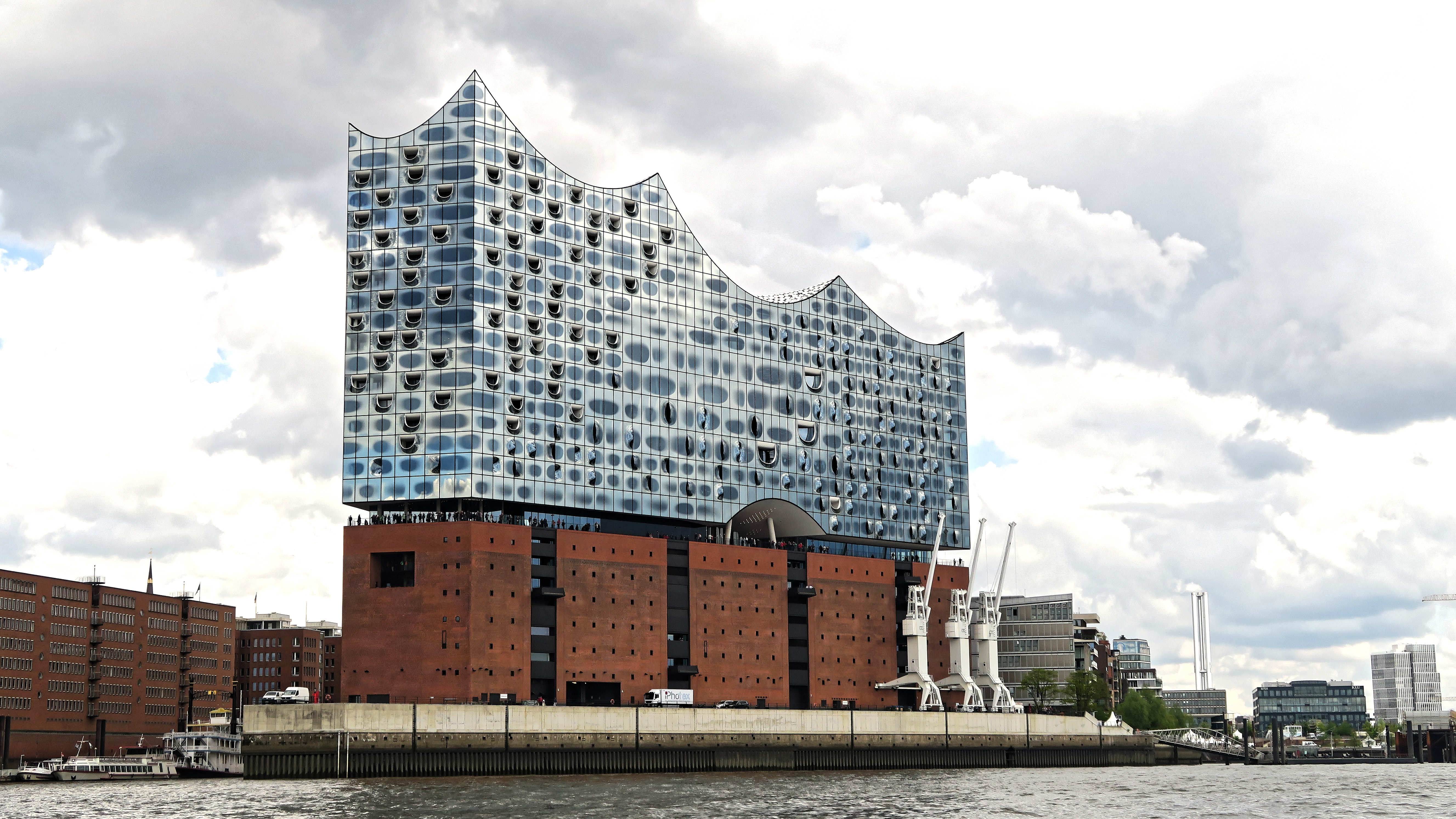 Exterior of the Elbphilharmonie showing the glass crystal superstructure atop the brick Kaispeicher warehouse base.