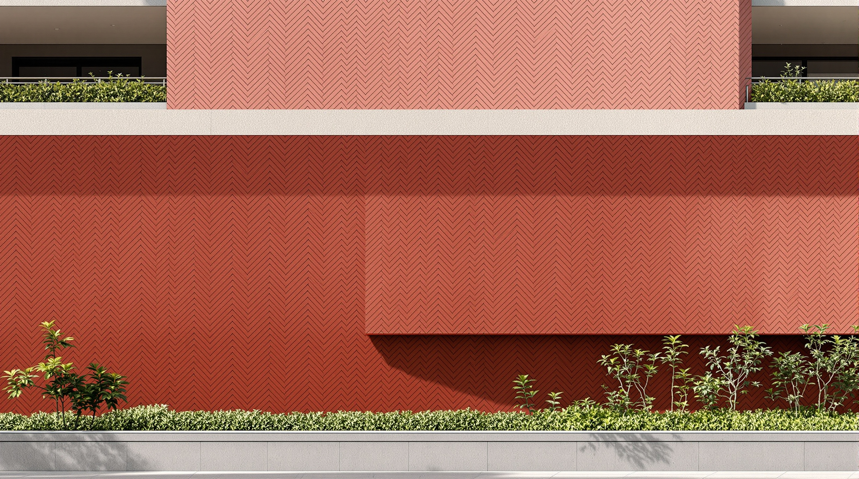 Detail of EPIQ's façade: matte pigmented cement tiles laid in a herringbone pattern across a rounded-cornered concrete volume, the tiles shifting between four distinct shades of red, with a planted terrace and low green wall meeting the tiled surface at a step-back