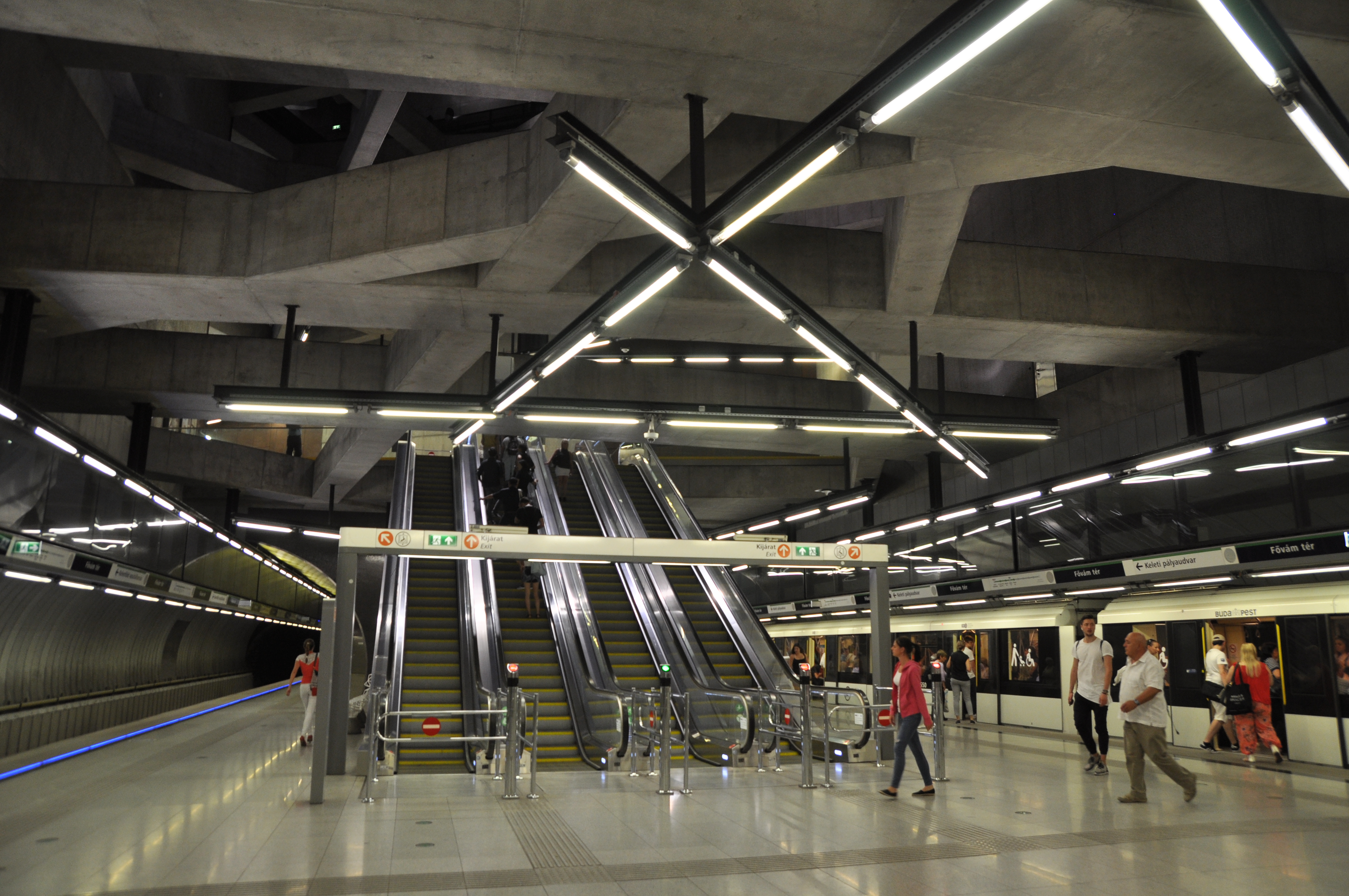 Interior view of Fővám tér M4 station showing the exposed concrete beam structure of the cut-and-cover box.