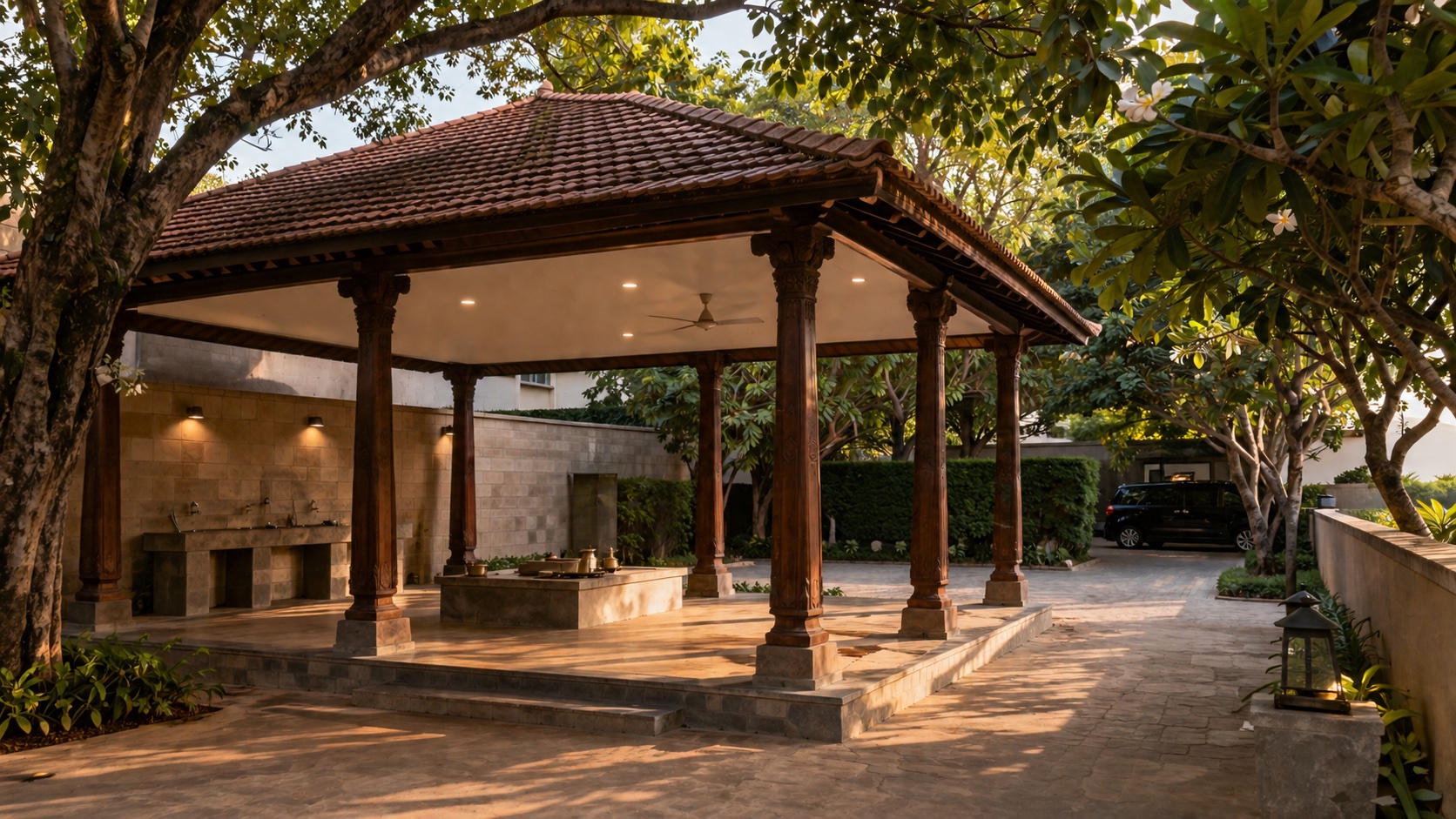 Outdoor last-rites pavilion — sloped tile roof, carved teak columns, dignified outdoor family-ritual space