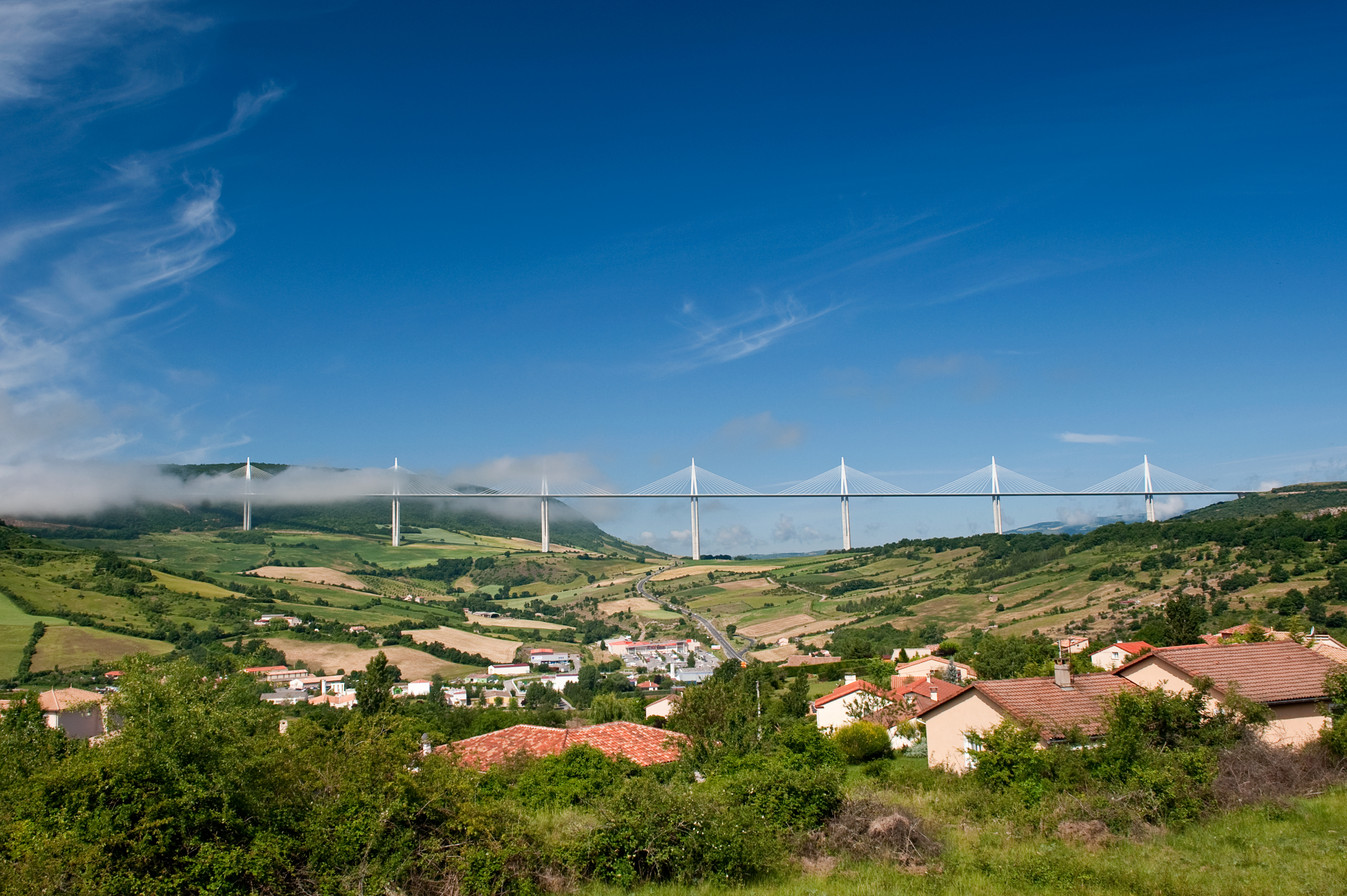The viaduct rising above the town and rooftops near Millau, showing its scale against the landscape.