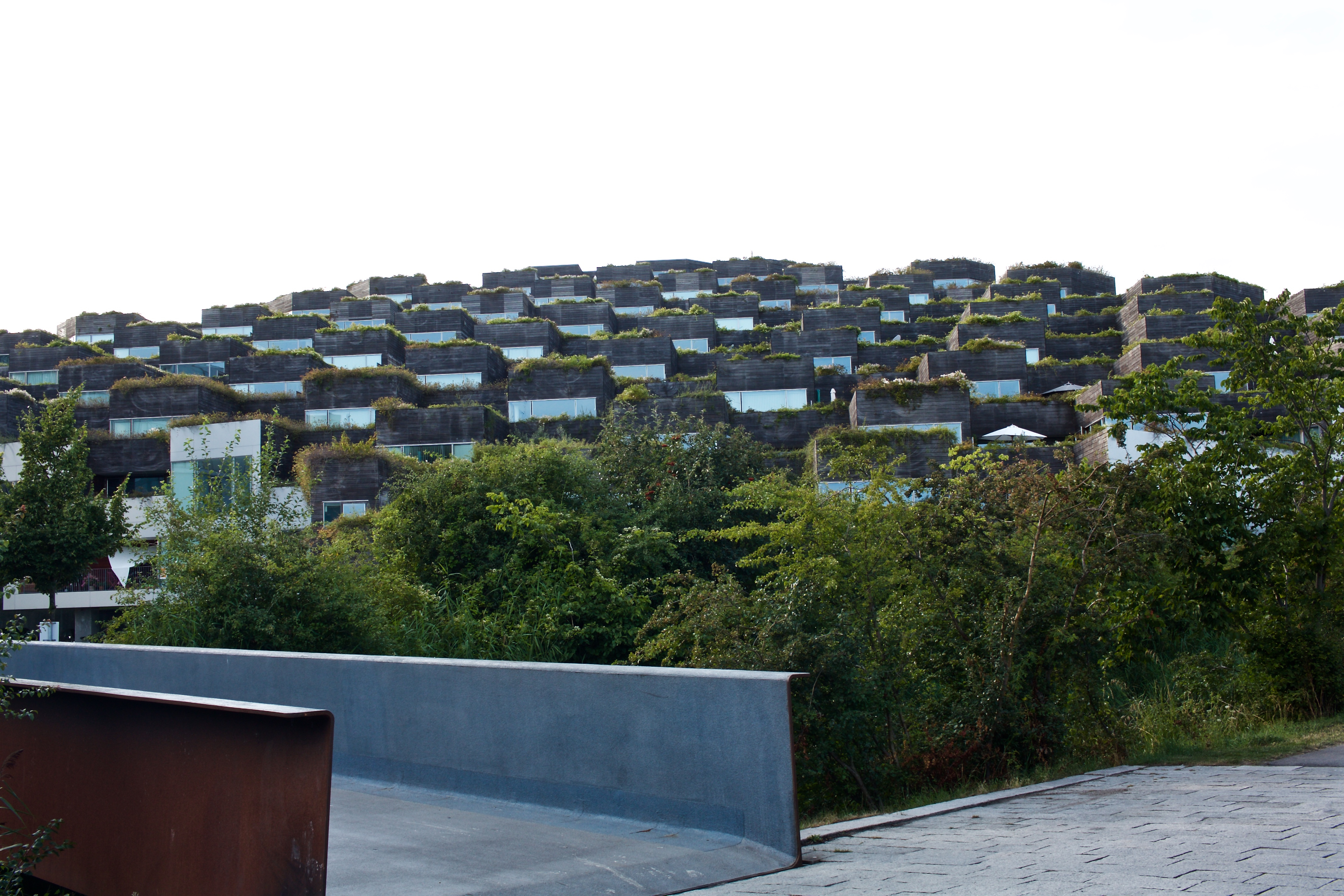 View of the terraced apartments cascading down the diagonal sloping roof of the parking garage.