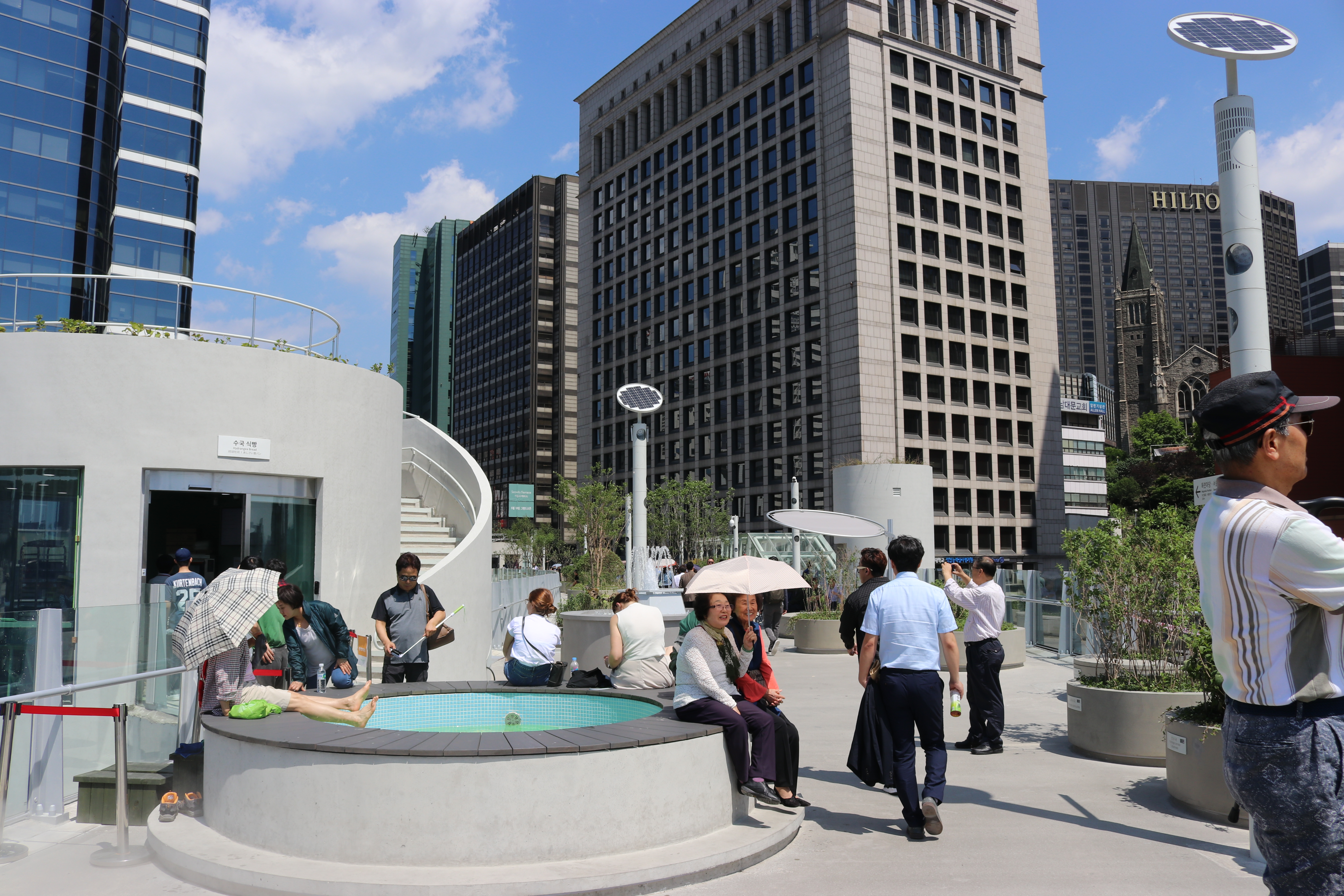 View along the elevated concrete deck of Seoullo 7017 with its rows of round concrete planters.