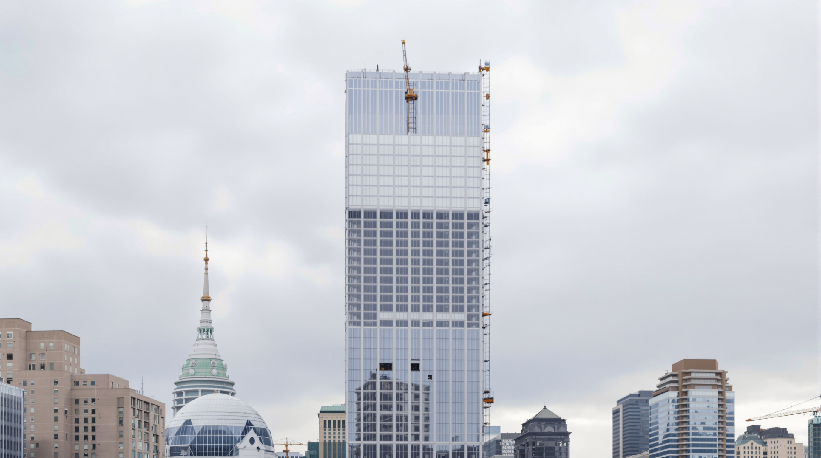 The Greenwich topped out but incomplete during its long construction pause, a bare glass-and-concrete tower standing conspicuously among the finished skyscrapers of Lower Manhattan under an overcast sky