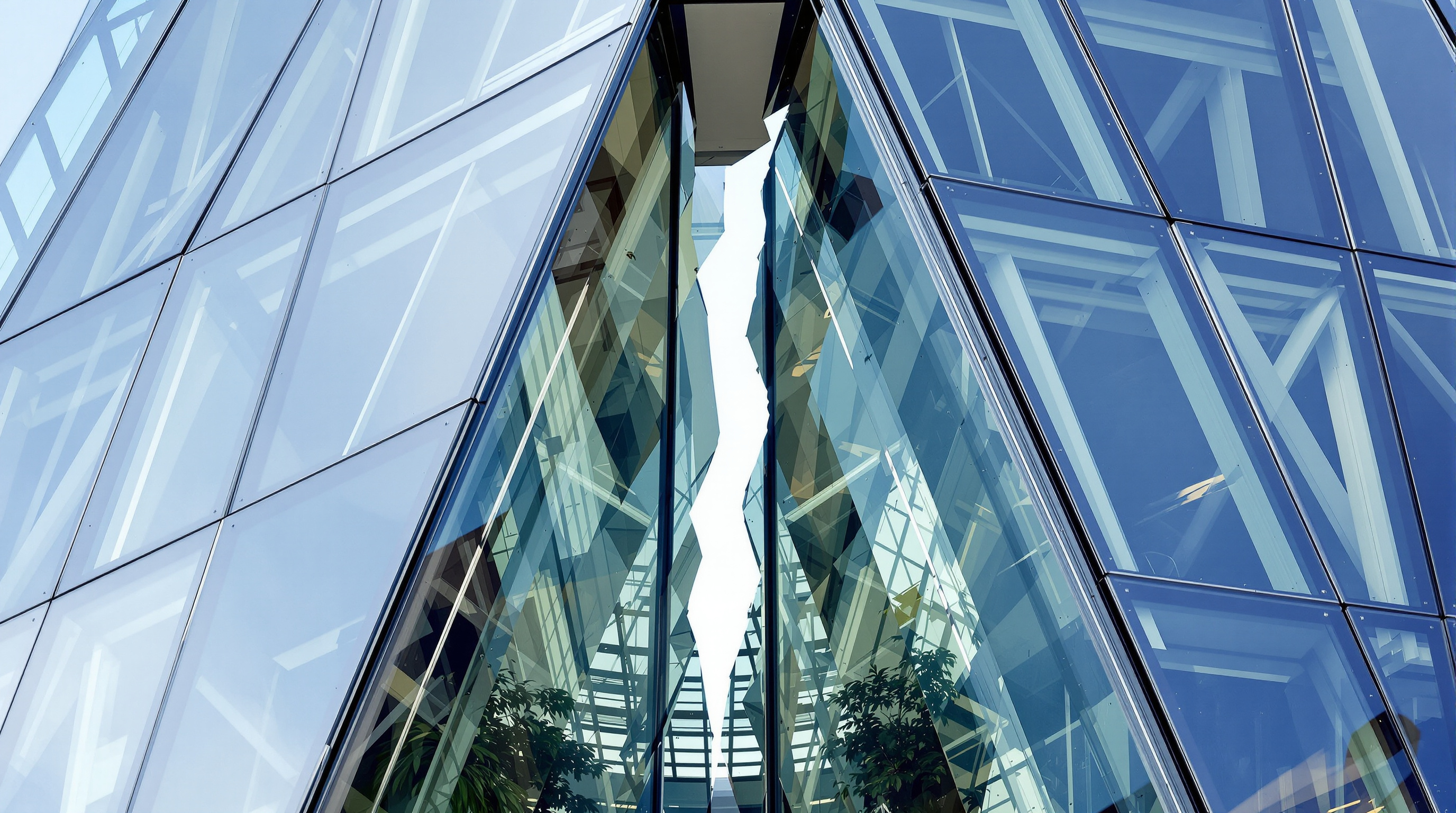 Detail of the Shard's faceted glazing where two of the eight inclined glass planes fail to meet, leaving an open fracture; angled panels catch the light at different pitches, and a naturally ventilated winter-garden void sits behind the gap