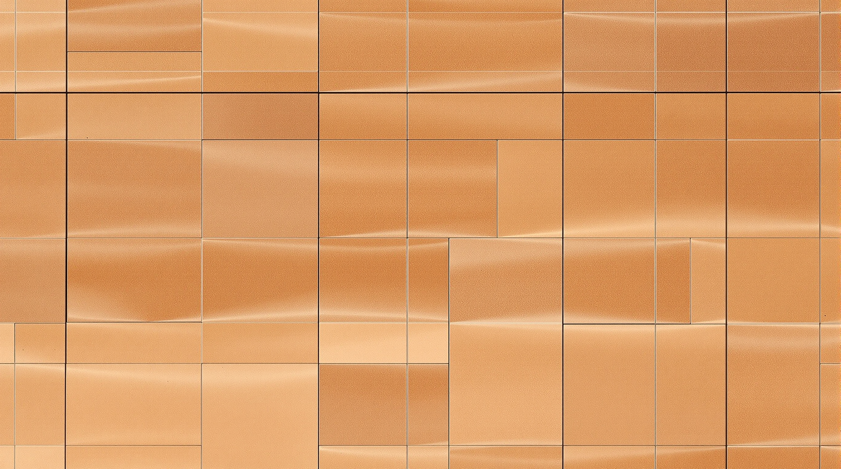 Detail of the UCCA Clay Museum facade, rows of handmade ceramic tiles in gradients of chestnut and pale brown, each tile faintly uneven and individually glazed, catching low afternoon light across the curving wall