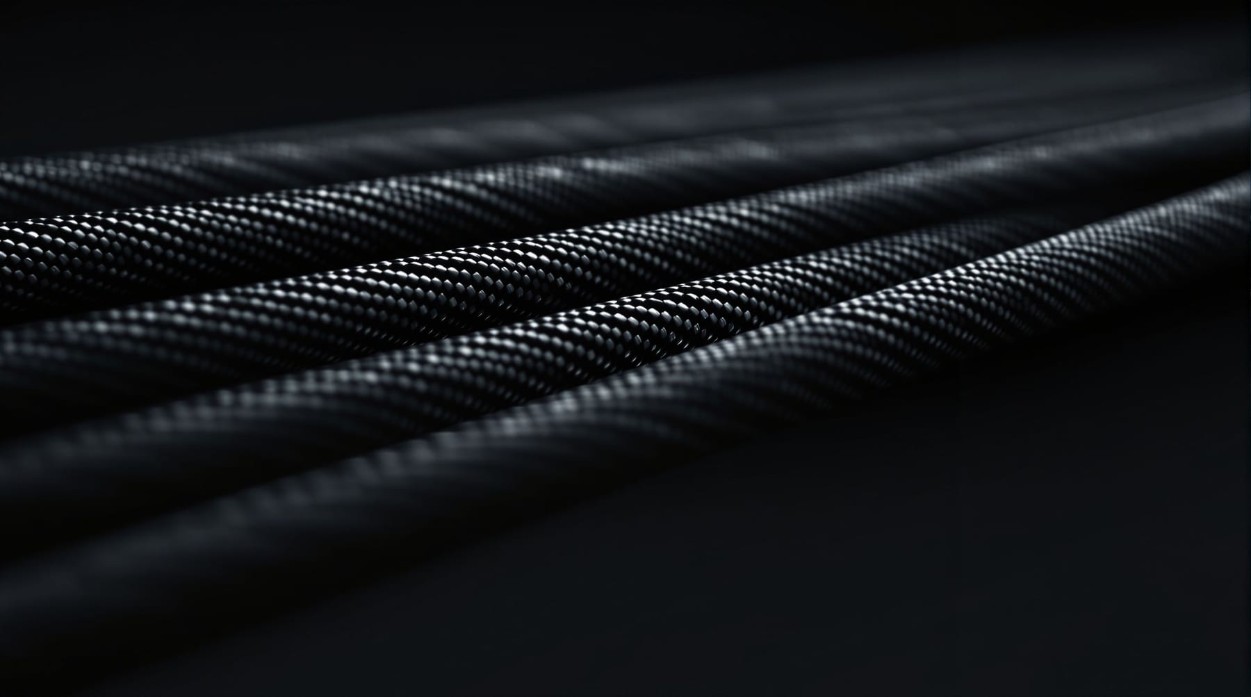 Macro close-up of braided carbon-fibre composite strand rods running diagonally against a dark background