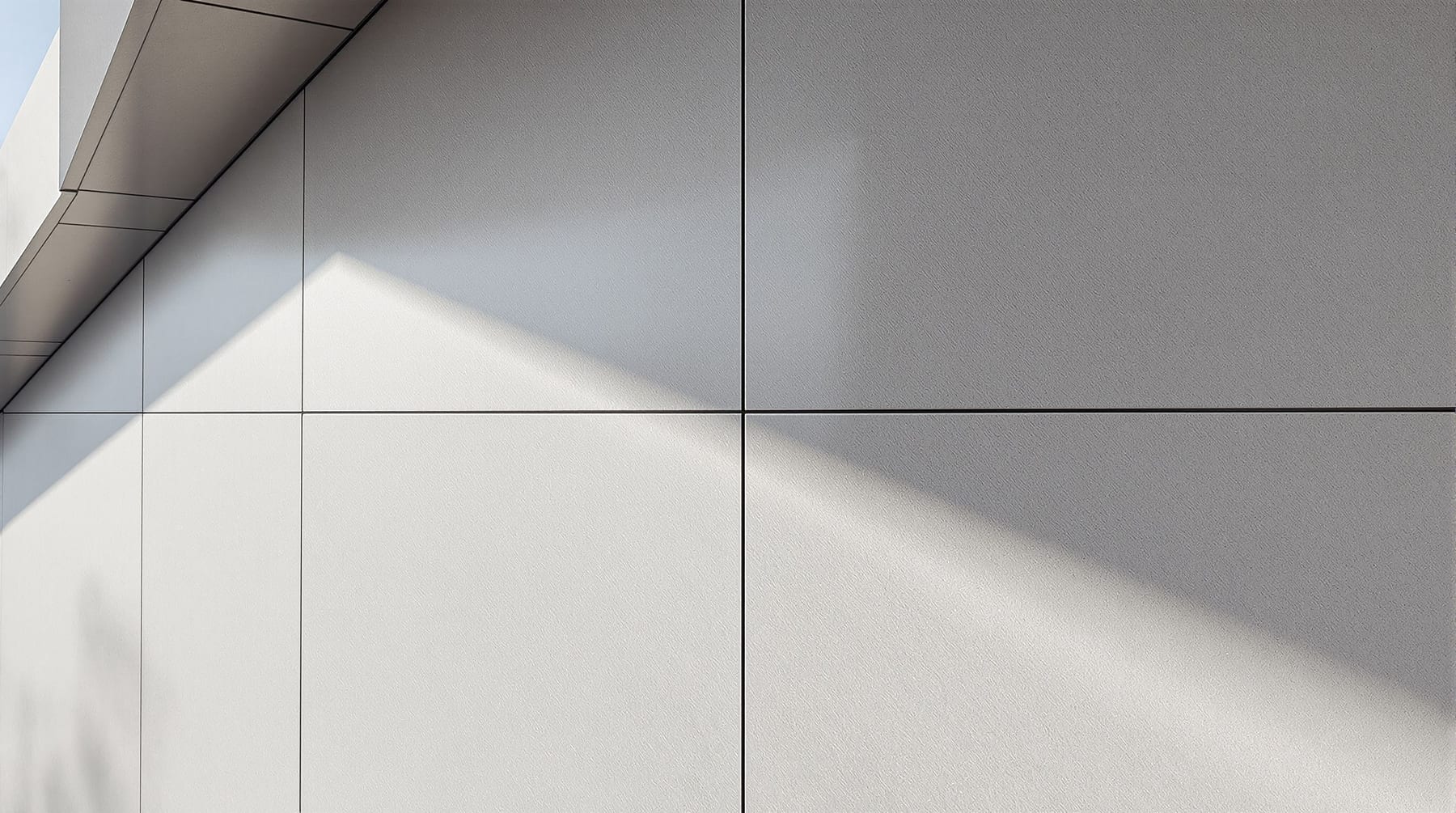 A large-format sintered stone facade of big matte marbled slabs fitted with fine shadow-gap joints