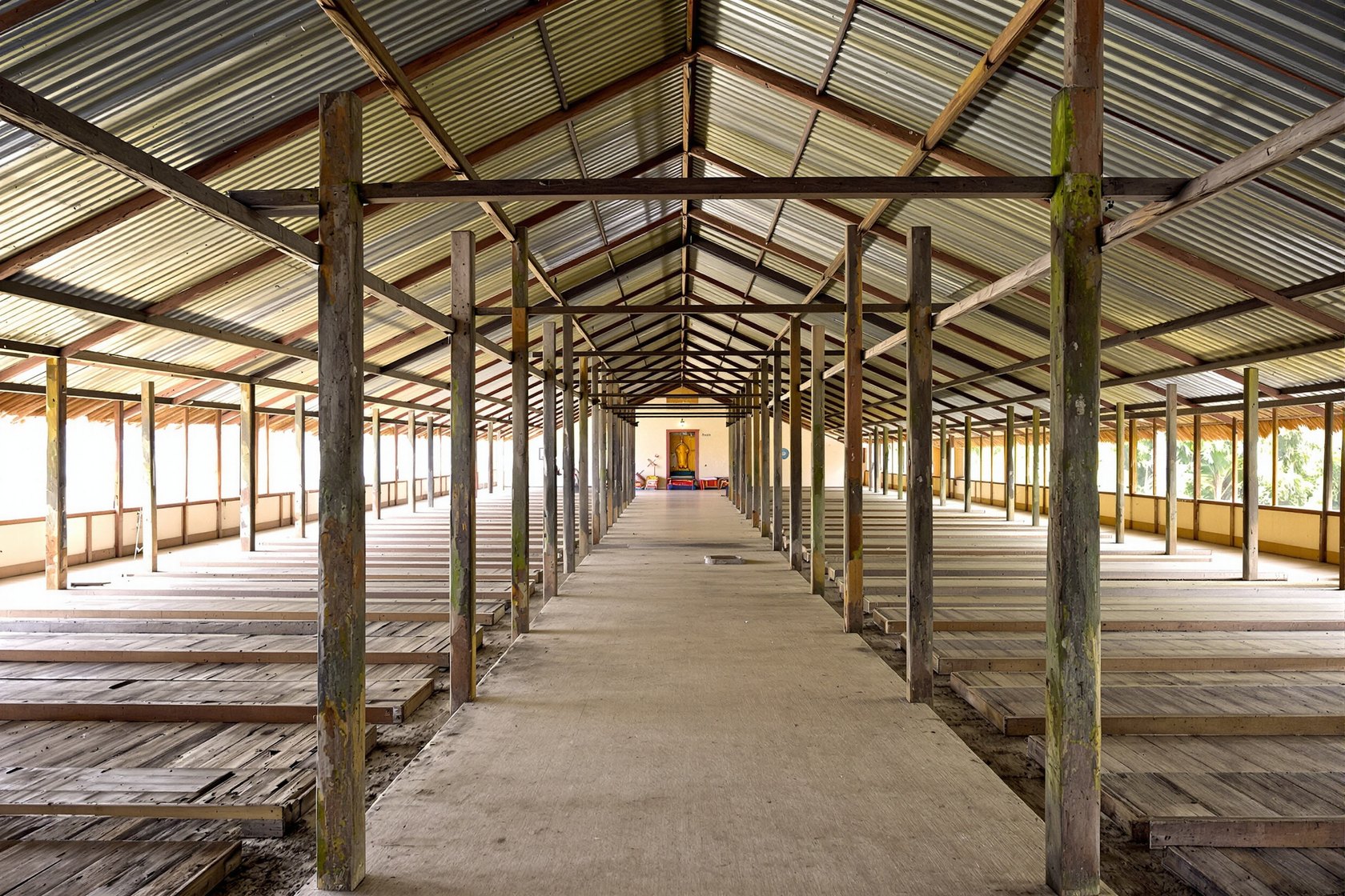 The long open timber-post prayer hall (namghar) of an Assamese neo-Vaishnavite satra under a low pitched roof