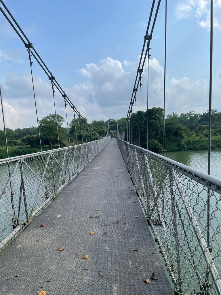 A suspension footbridge crossing the water near the sanctuary