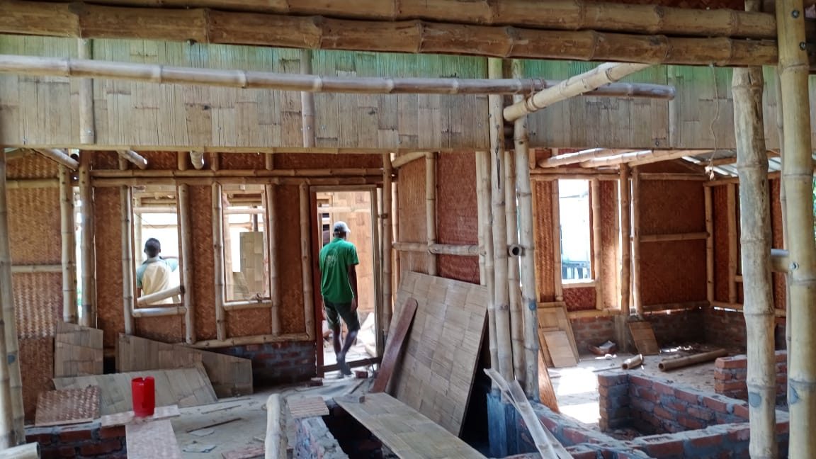 A barrack interior with woven-bamboo walls, a timber floor and windows for cross-ventilation