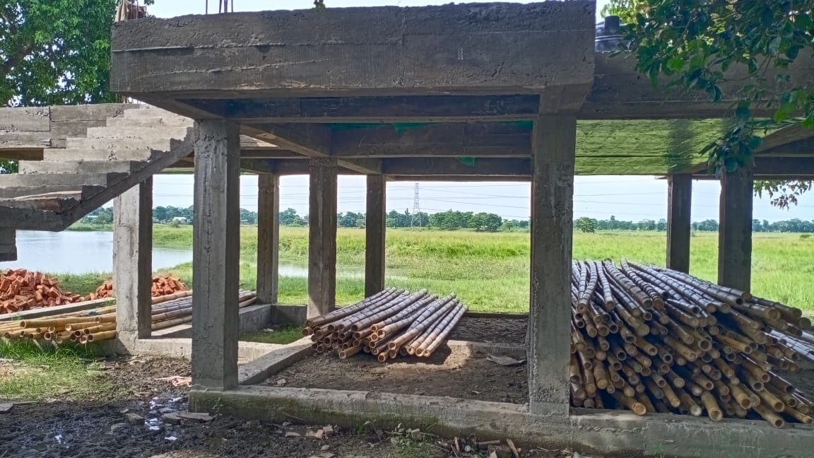 The underside of the raised barracks — a columned platform lifting the living floor above open ground, floodplain beyond