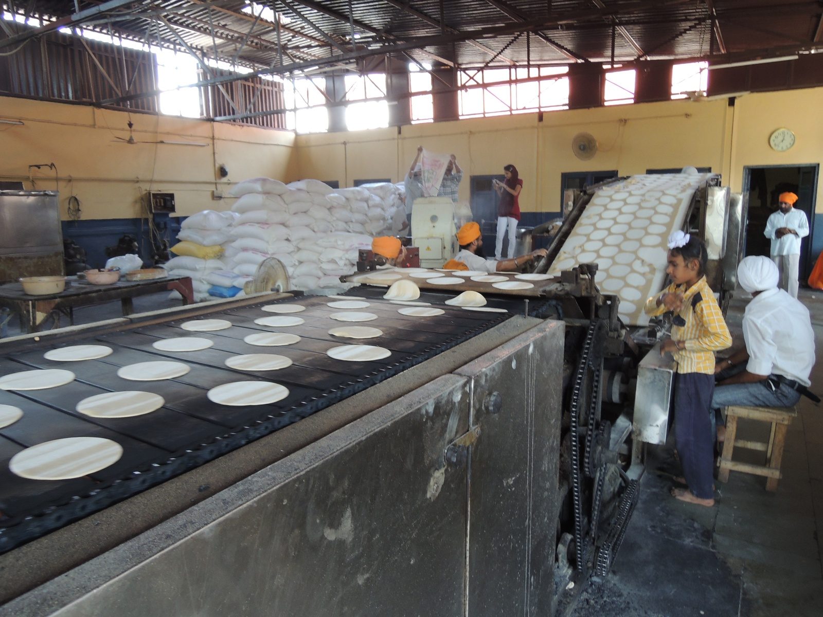 An automatic chapati-making machine turning out rotis at scale in the Guru Ka Langar kitchen at the Golden Temple