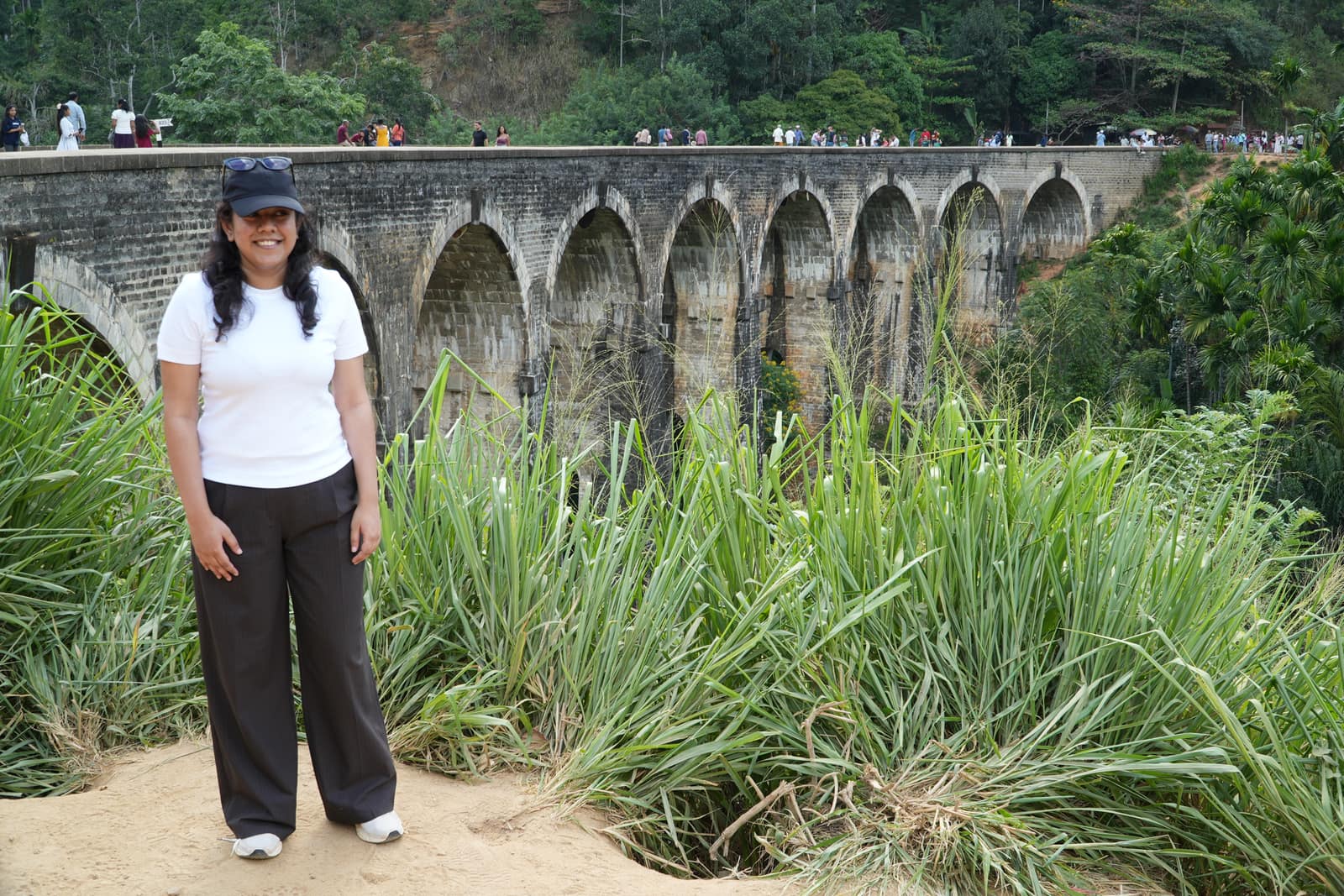 The magazine's Digital Editor standing on the path in front of the Nine Arch Bridge, the full run of stone arches carrying the railway across the gorge behind her
