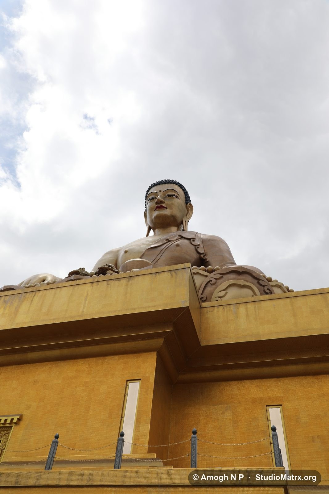 The Buddha Dordenma seen from the foot of its throne, the gilded walls of the throne hall filling the lower half of the frame