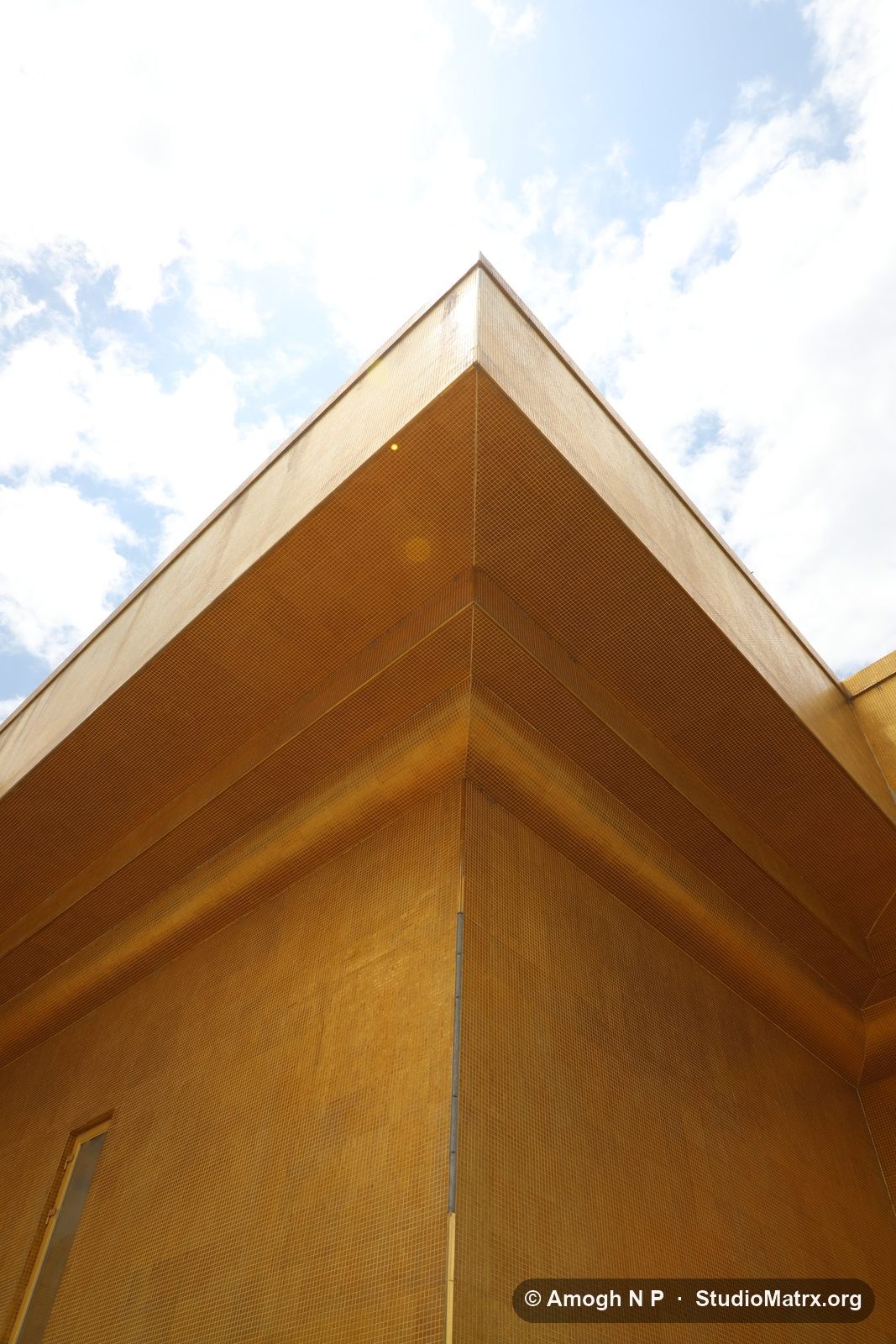 A gilded corner of the Buddha Dordenma throne hall, a sharp gold edge against blue sky