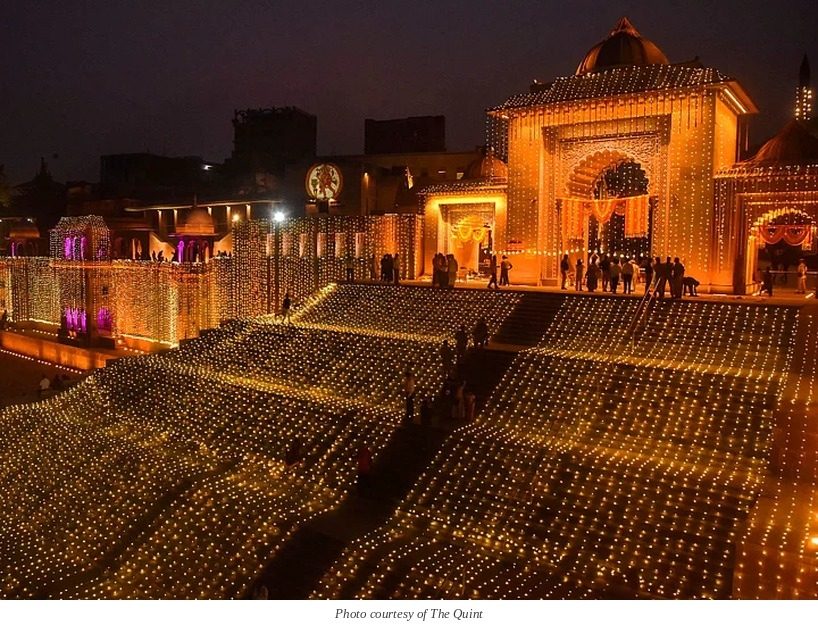 A building and its stepped forecourt covered in small warm lights at night