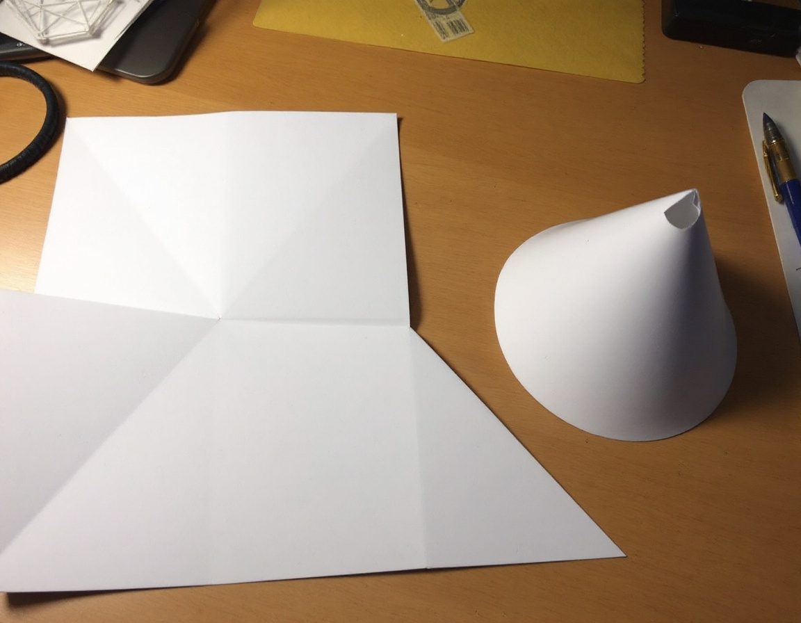Flat development patterns of a cone and a pyramid, part-folded.