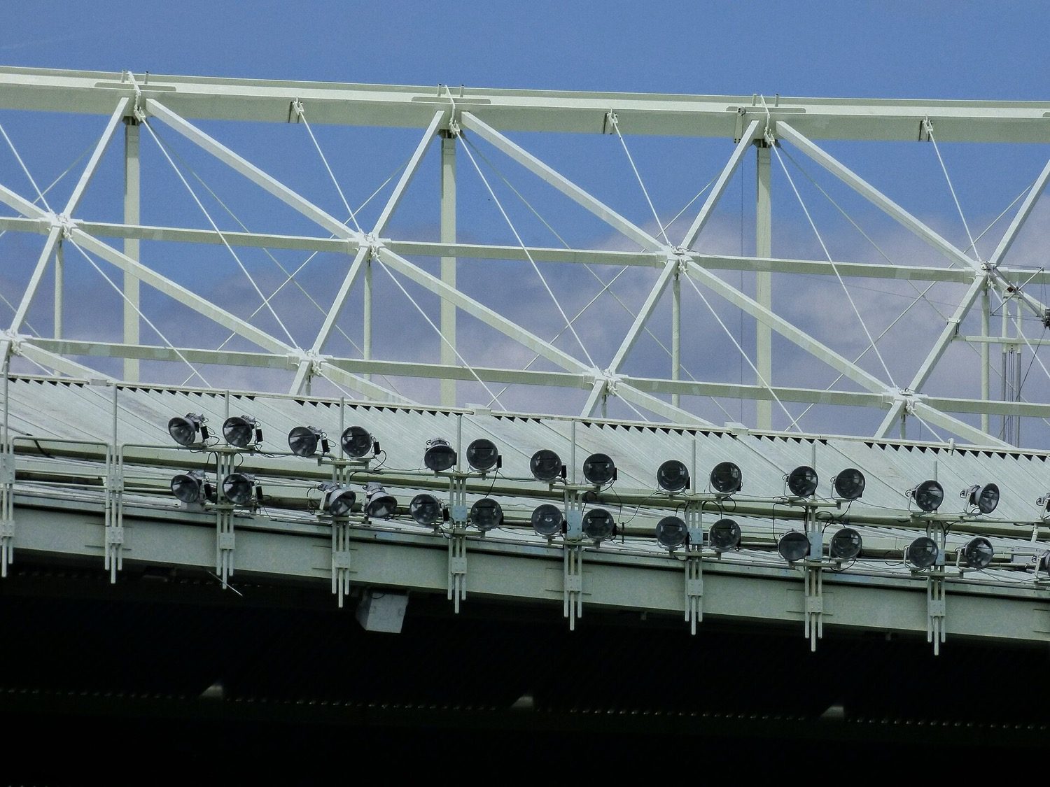 A steel stadium roof — profiled metal sheeting carried on a steel truss structure.