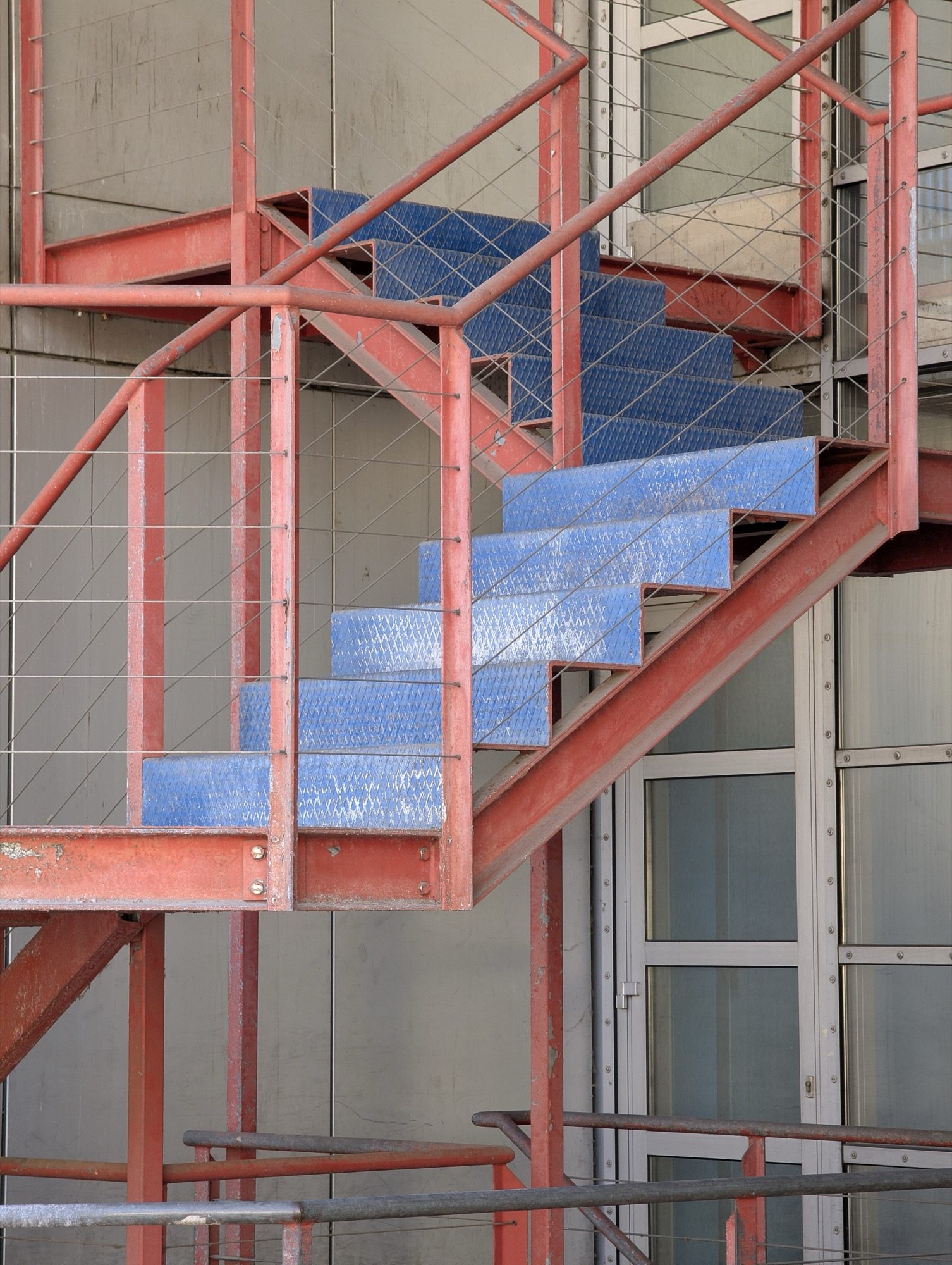 A steel staircase — stringers, treads and a steel balustrade carrying the climb.