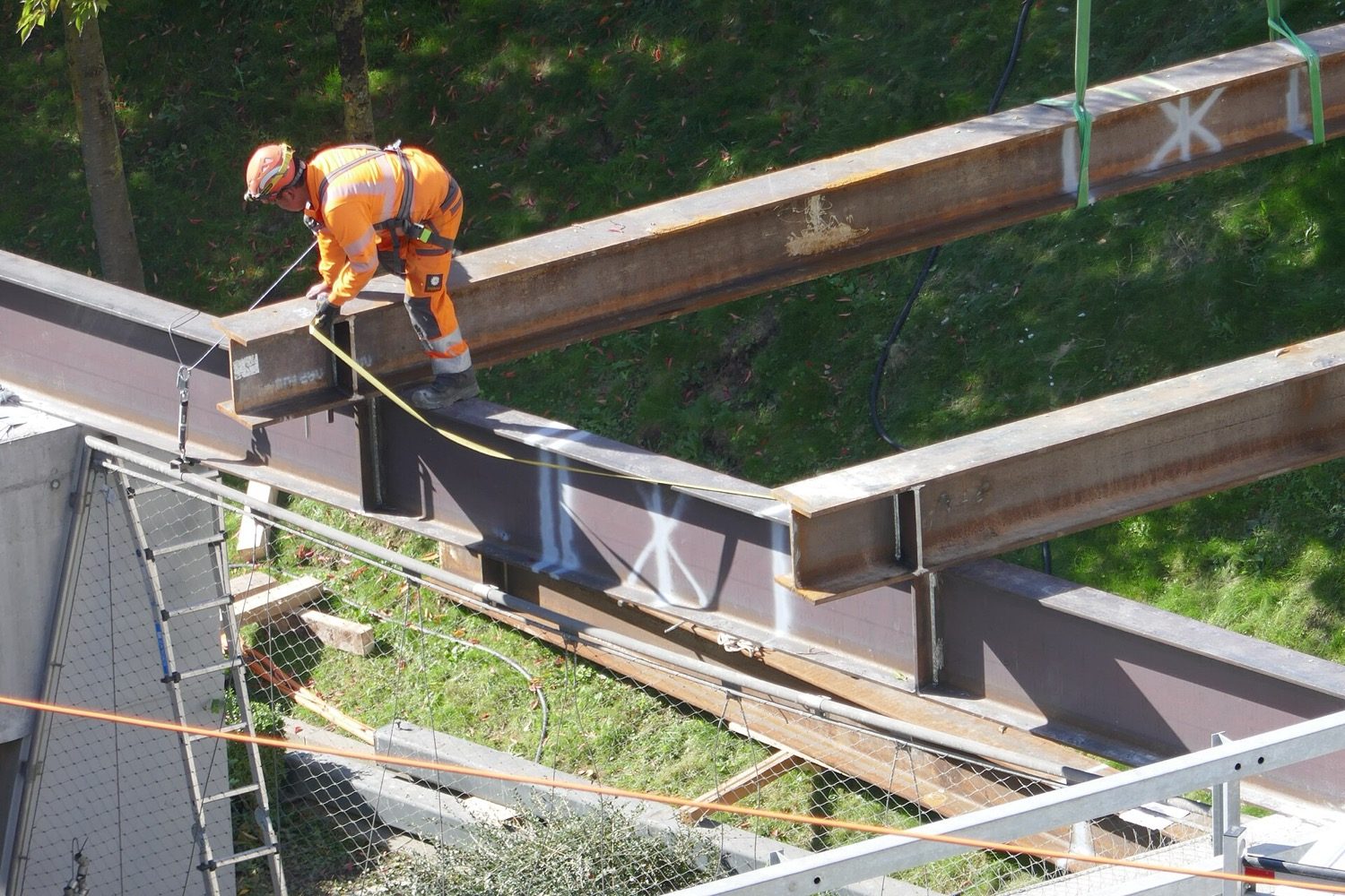 Hot-rolled steel I-sections being placed on site — the standard members of steel construction.