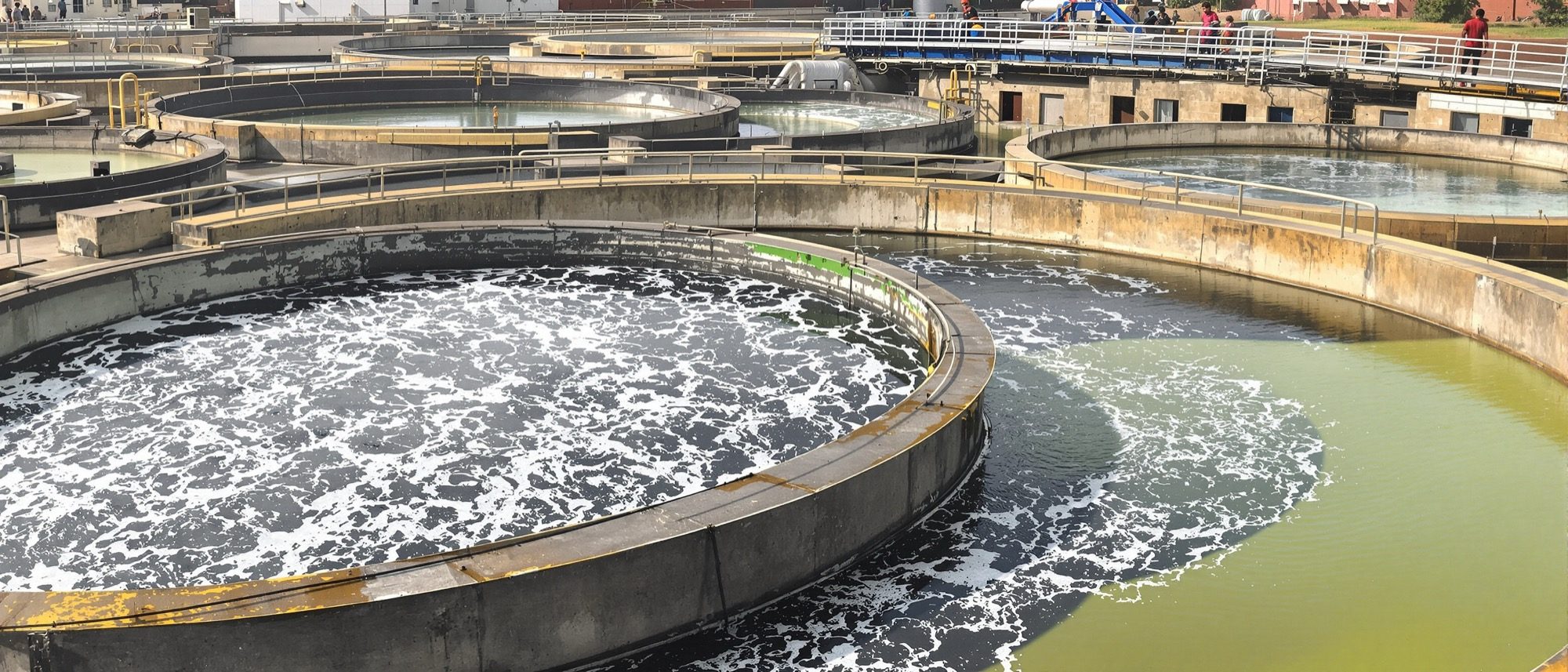 A sewage treatment plant with circular aeration and clarifier tanks — the activated sludge process in action.