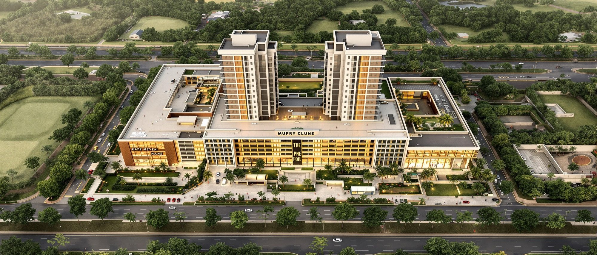 An aerial view of a mid-scale mixed-use complex on its landscaped site — a retail podium with towers above, separate vehicle and pedestrian routes, parking and open courts.