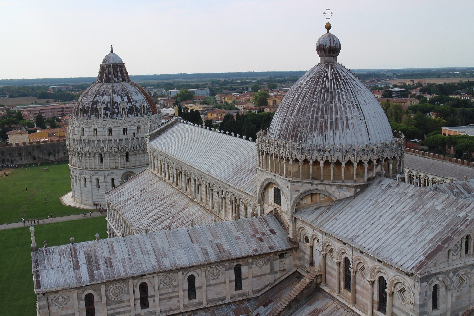 The cathedral and baptistery on the Piazza dei Miracoli at Pisa, seen from the Leaning Tower — banded marble and tiers of blind arcading, the type-piece of Pisan Romanesque.