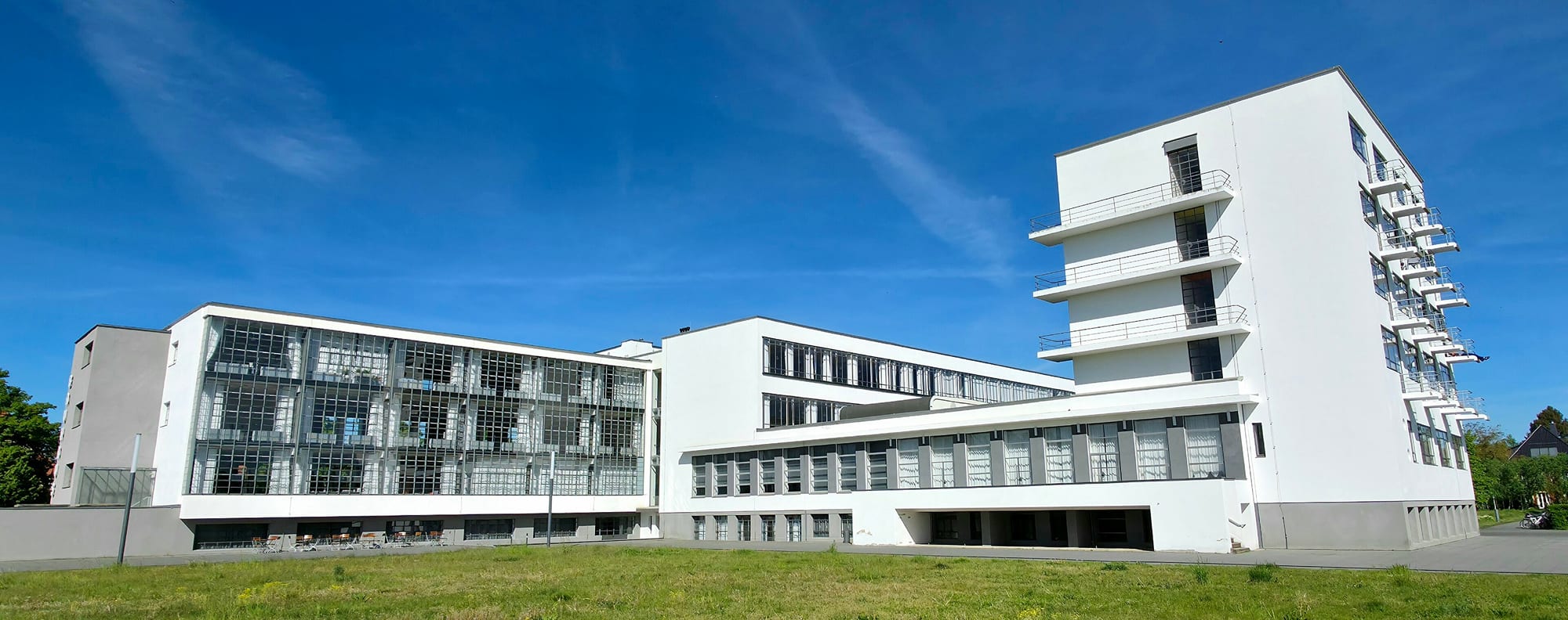 The Bauhaus building at Dessau (Gropius, 1926) — a glass curtain-walled workshop wing, interlocking asymmetrical volumes and flat roofs, with no ornament.