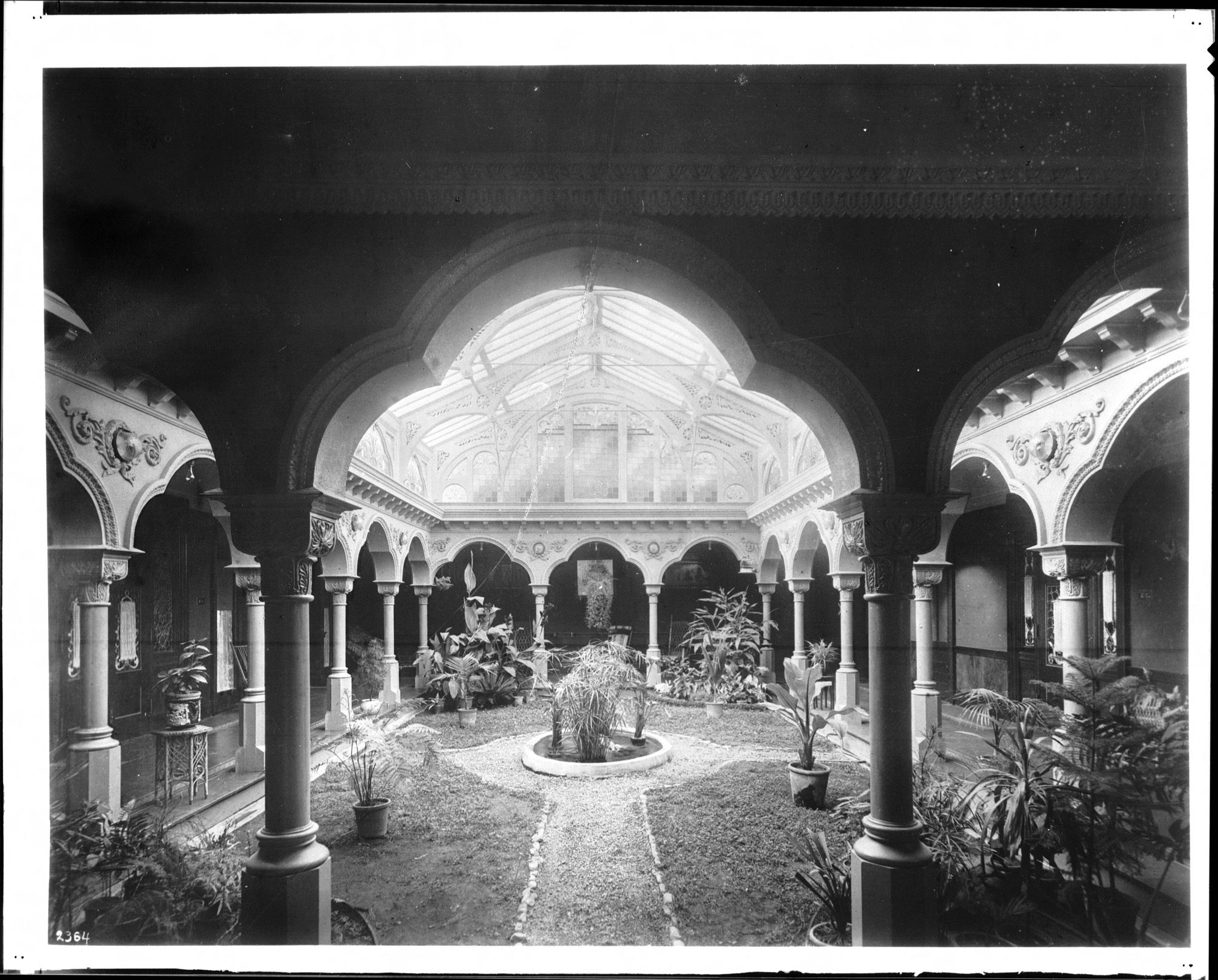 A planted interior atrium (a 1903 residence) — interior landscaping brings daylight, greenery and a central fountain into the heart of the building.