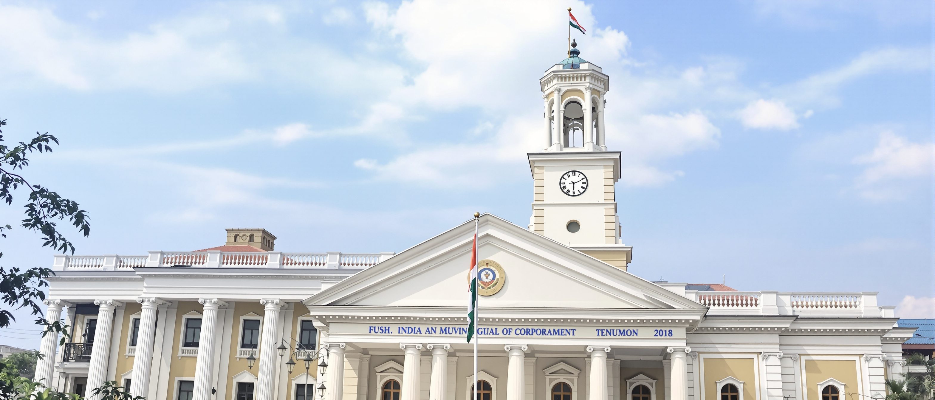 An Indian municipal corporation building with its civic facade and flag, the seat of local government that delivers planning, warm daylight, no people.