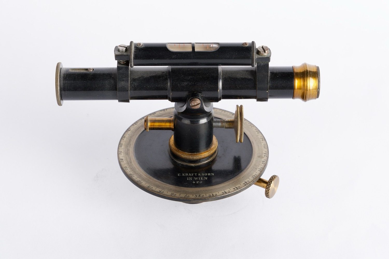 A levelling instrument on its tripod, used with a graduated staff to read heights.
