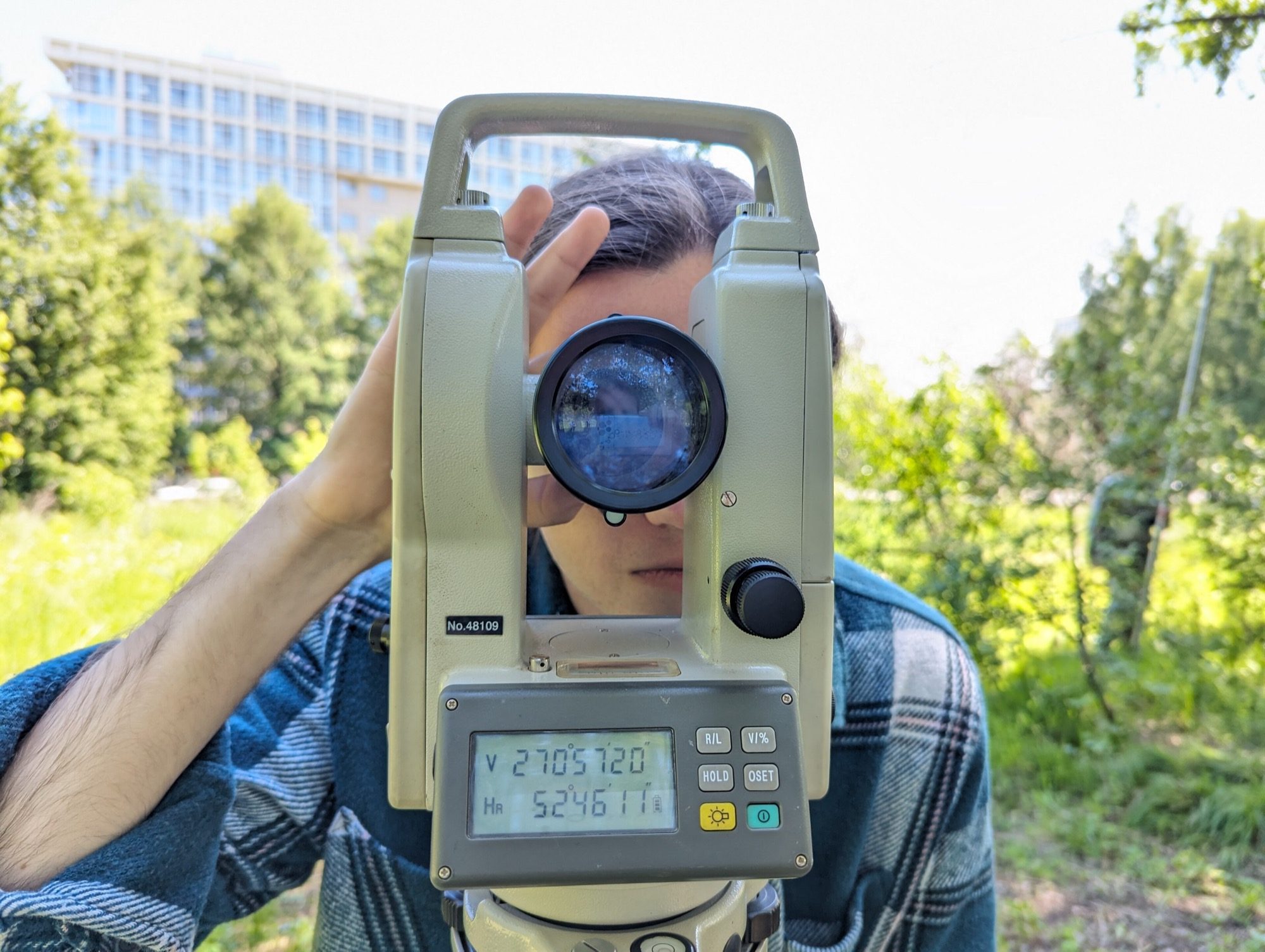 A theodolite set up on its tripod for measuring horizontal and vertical angles.