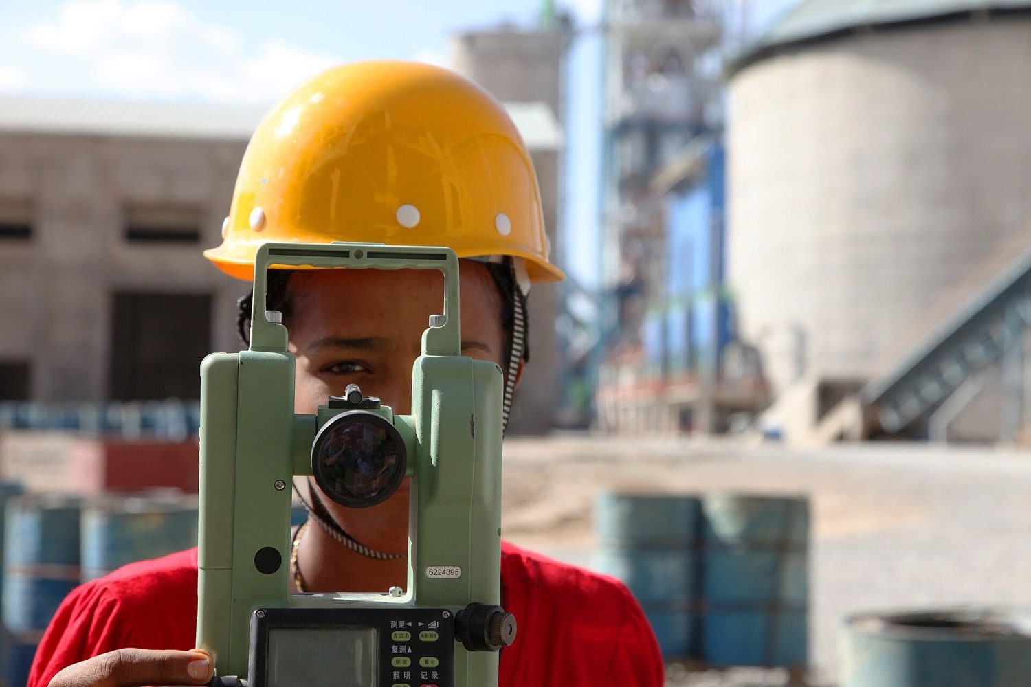 A surveyor at work in the field, fixing points and angles on the ground.