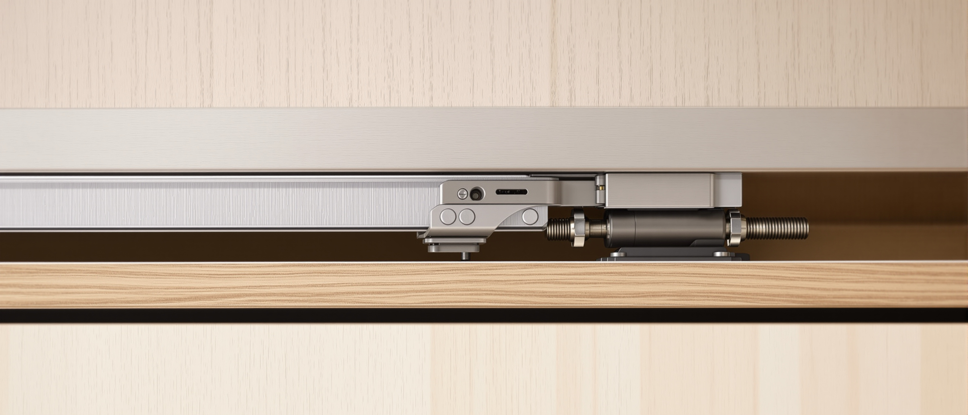 A close-up of a sliding-door top track with rollers, a concealed hinge and a gas strut on a light timber panel, workshop daylight, precise and technical, no text