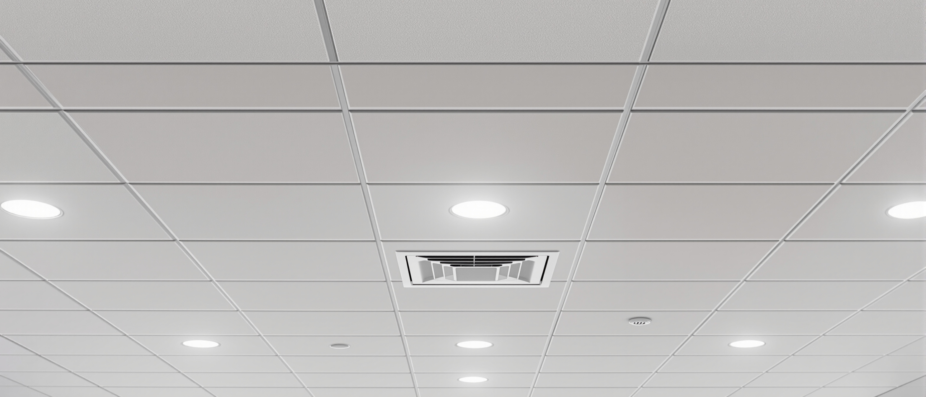 A real modular suspended ceiling from below — a grid of white tiles with recessed circular downlights, a square air-conditioning diffuser and a sprinkler head, clean modern interior, no text